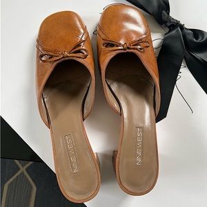 TWO PAIRS OF NINE WEST SHEATHO BOW FRONT LEATHER MULE HEELS BLACK, COGNAC/ CAMEL